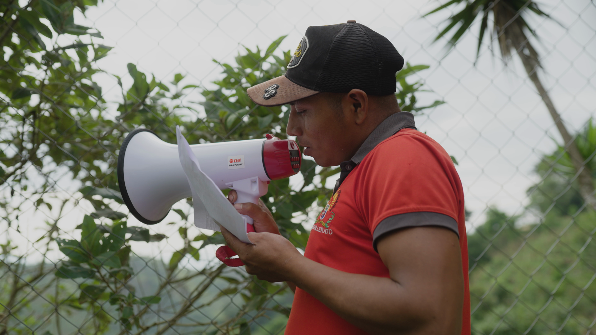 José promotional thumbnail: José speaking into a red-and-white megaphone outdoors.